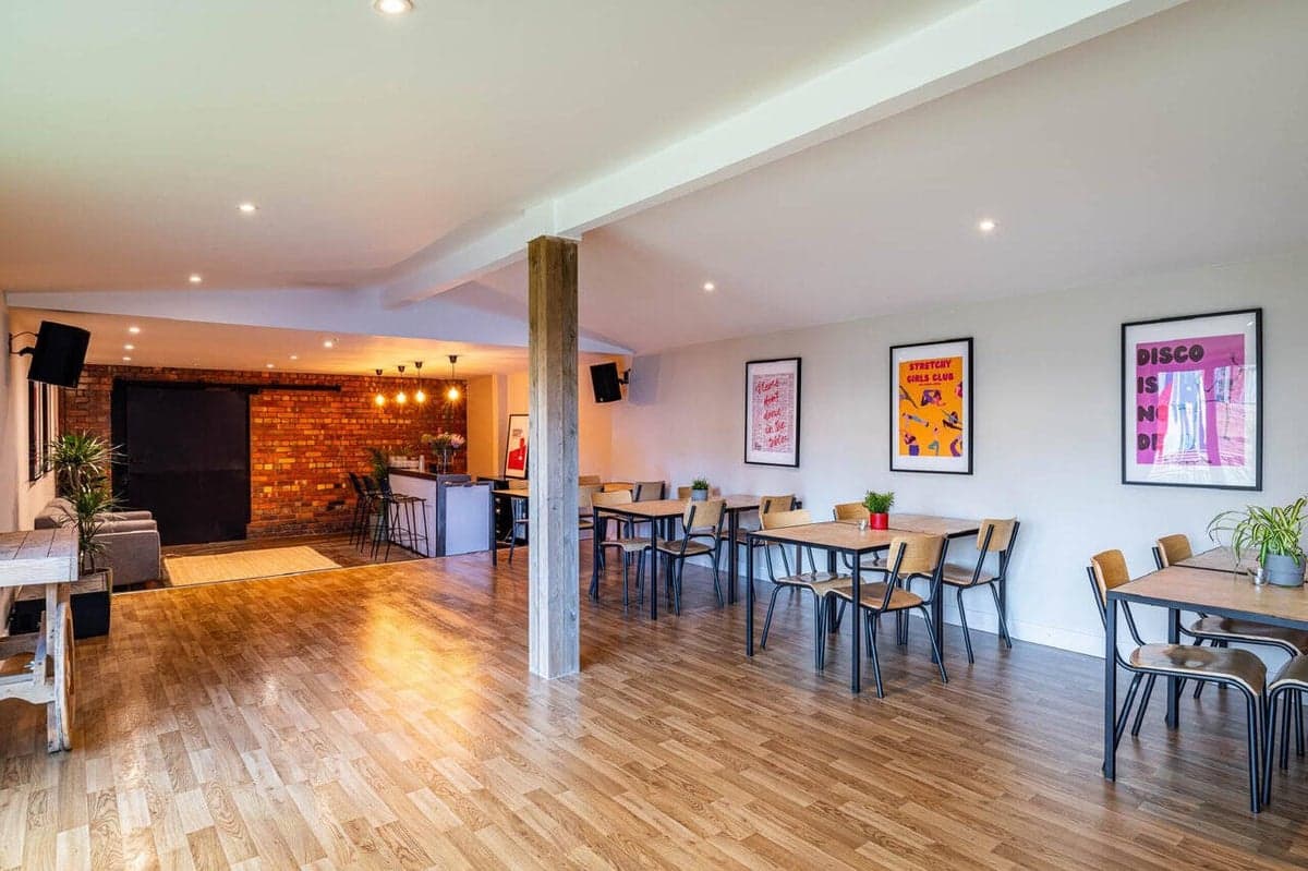 The bright upstairs room with tables, bar and gallery posters