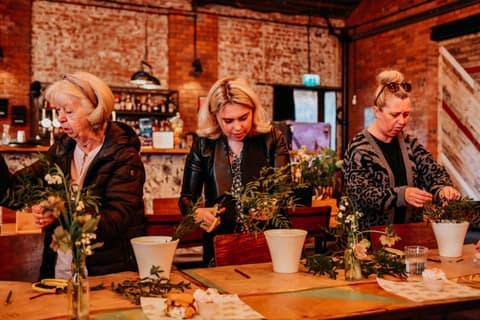 Guests making flower arrangements at a workshop in the warehouse